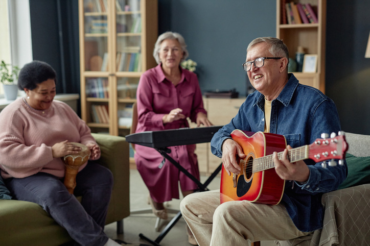 Three older adults playing instruments