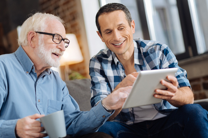 Older man and middle-age man looking at tablet