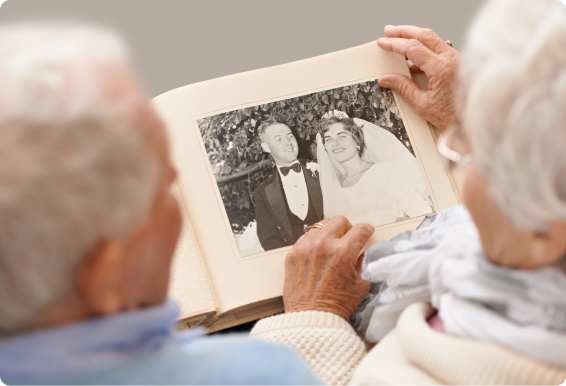 An old married couple looks at their wedding photo