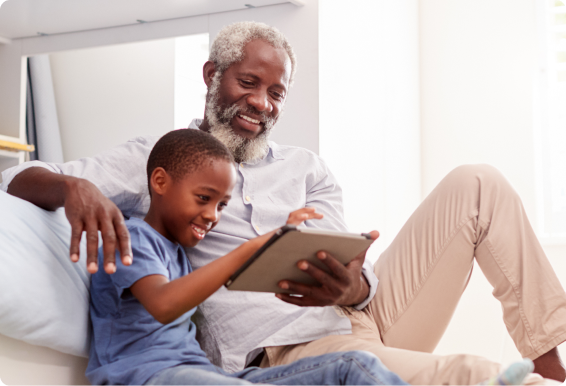 A grandfather and child use a tablet together