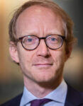 portrait of man with reddish hair and glasses looking at the camera