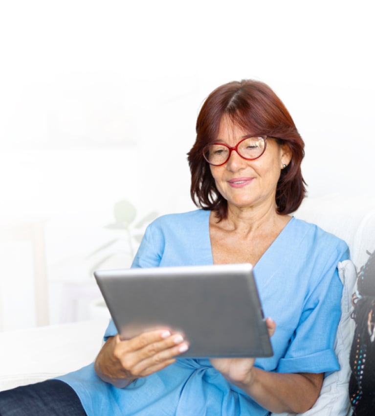 Woman sitting on couch looking at tablet